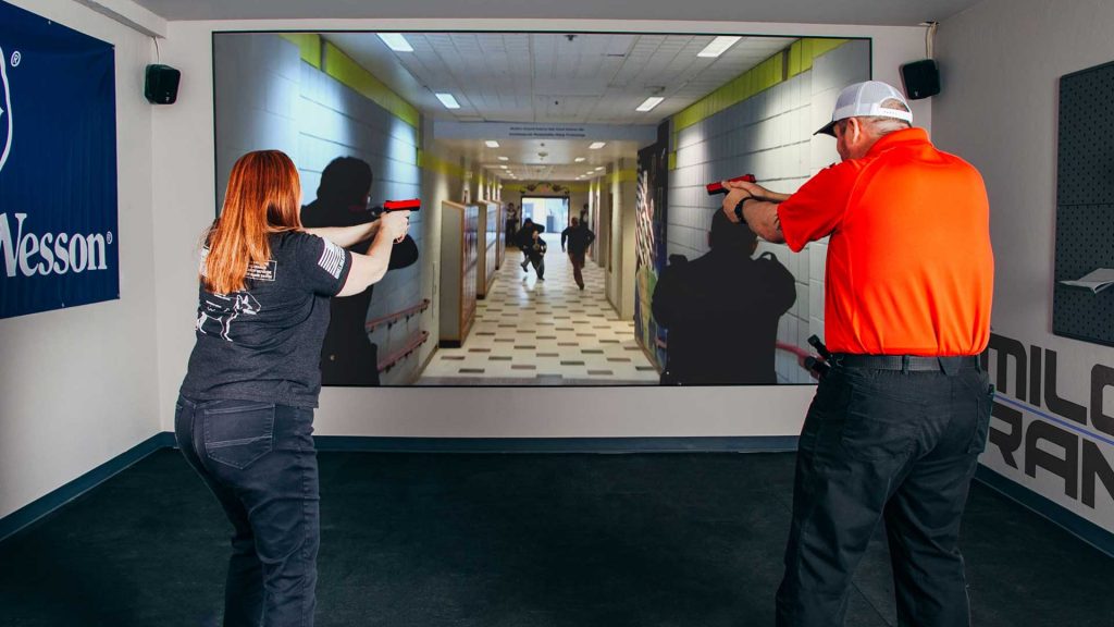 a man and a woman practicing virtual reality shooting range at the hub lakeside