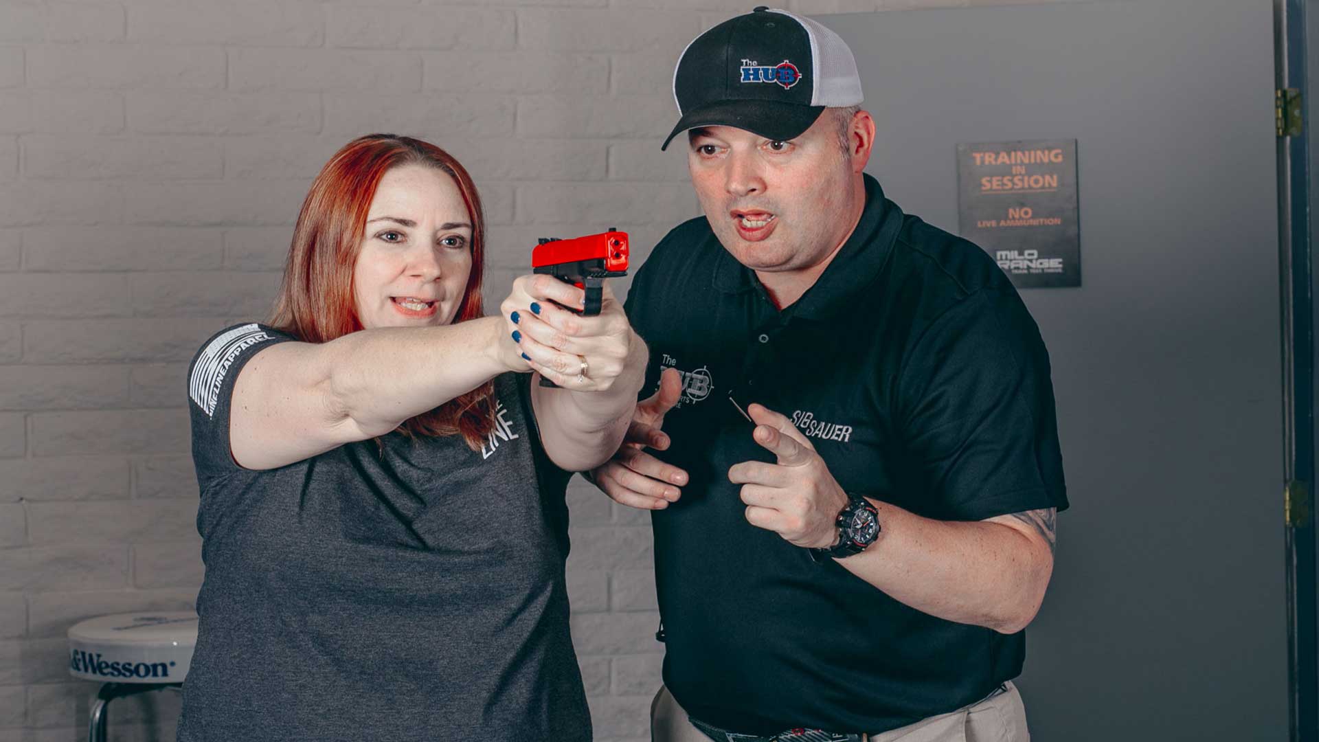 the hub mesa instructor teaching a woman how to properly fire the gun