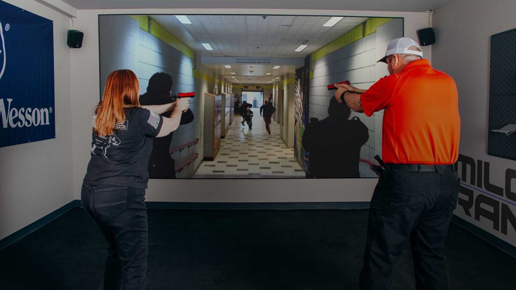 a man and a woman practicing virtual reality shooting range at the hub