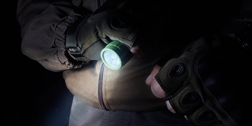 a person using a tactical flashlight