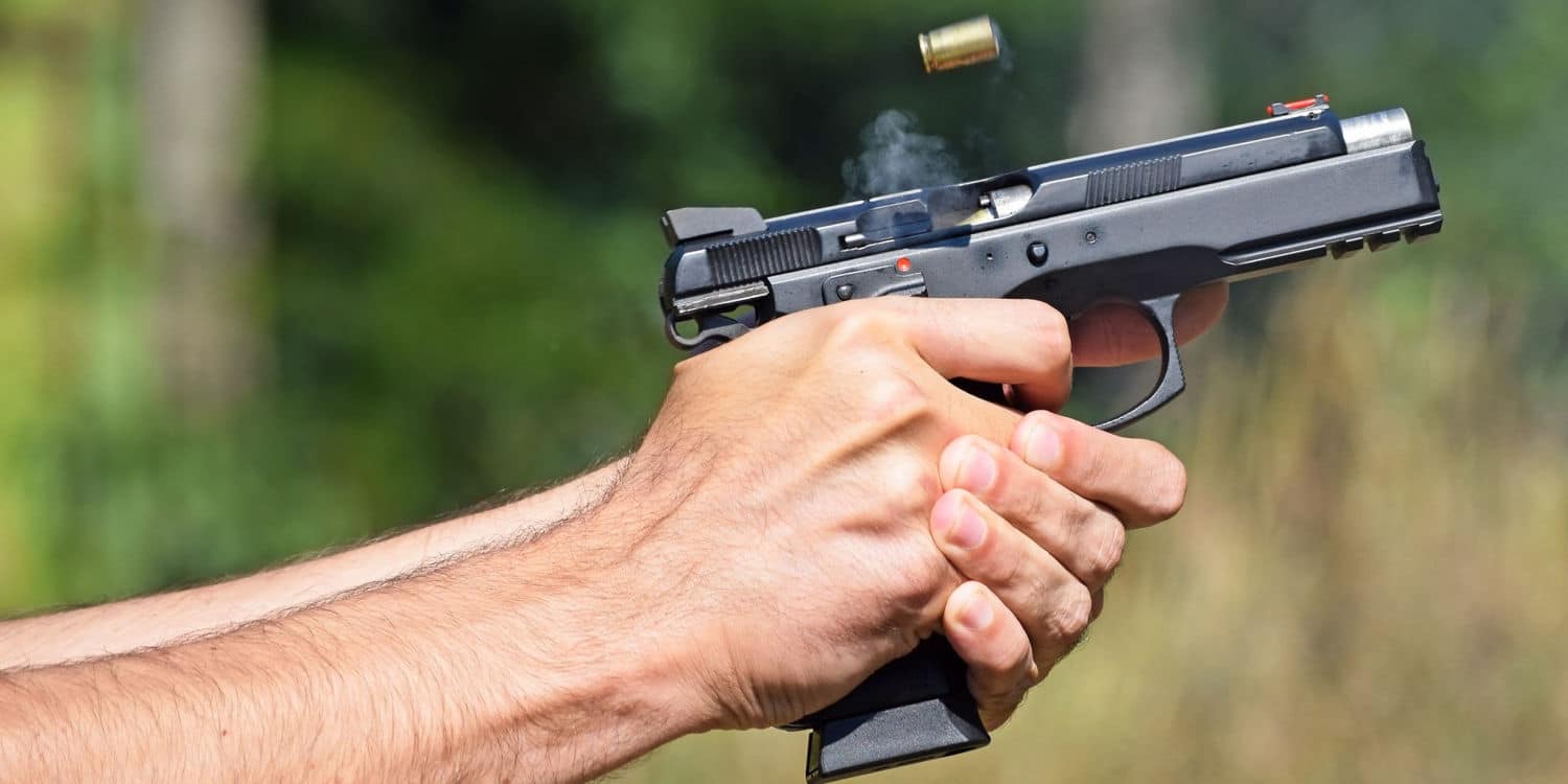 a person with excellent shooting accuracy holding a handgun and firing it