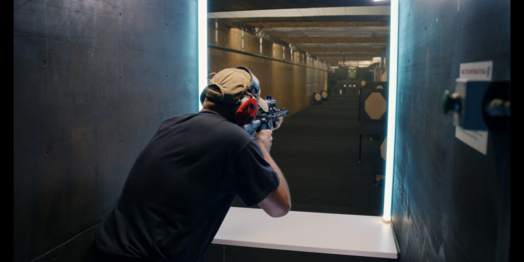 a man practicing in a shooting range with a sniper rifle