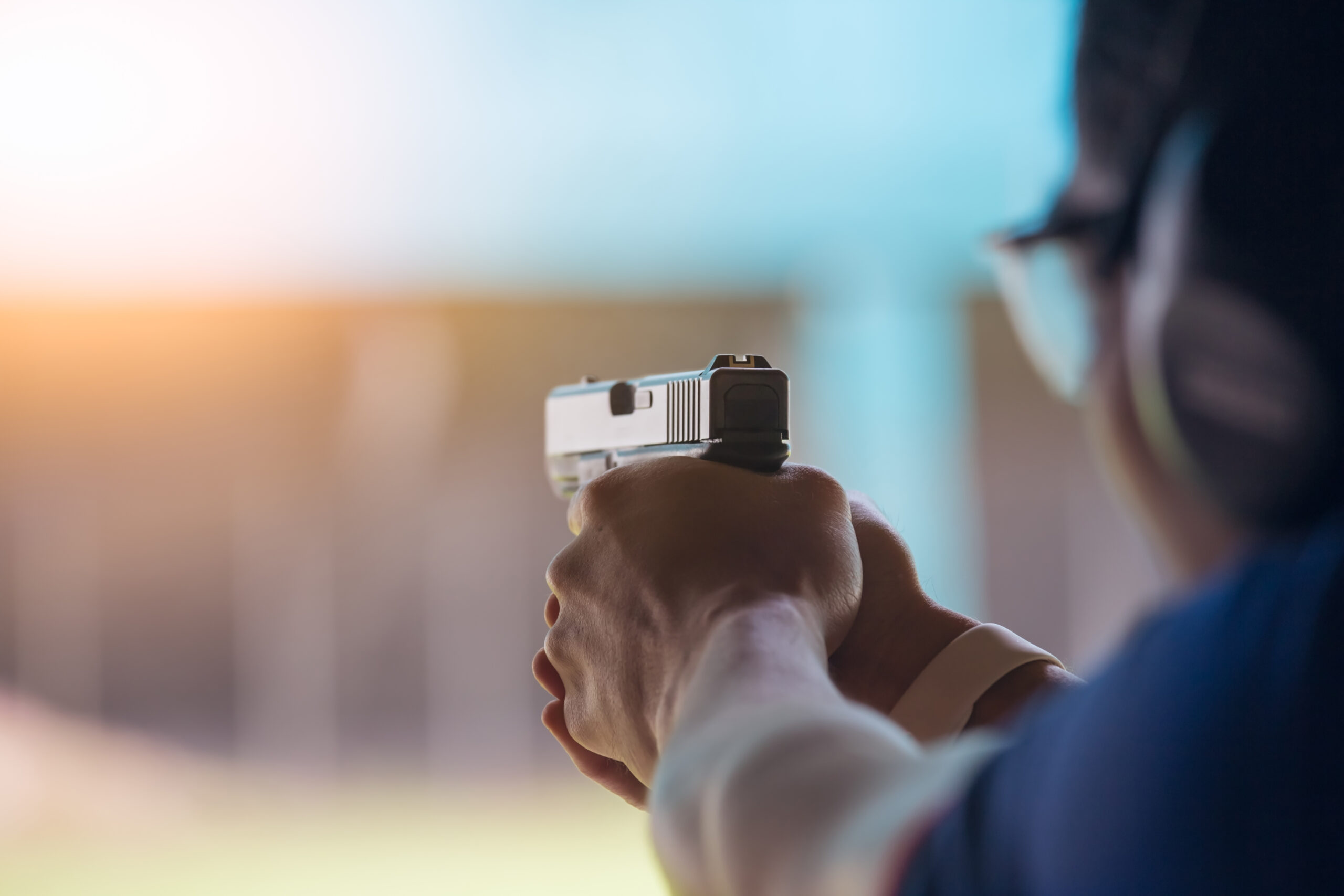 a man shooting a rental gun at a gun range